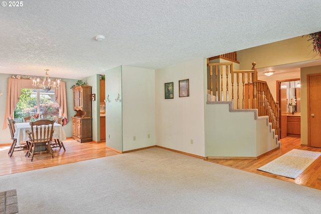 230 S Maple Hill Rd, Kelso, WA 98626 - unfurnished living room featuring a chandelier, carpet flooring, a textured ceiling, stairway, and wood finished floors