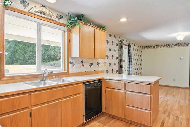 230 S Maple Hill Rd, Kelso, WA 98626 - kitchen with black dishwasher, a sink, a peninsula, light wood-style flooring, and light countertops