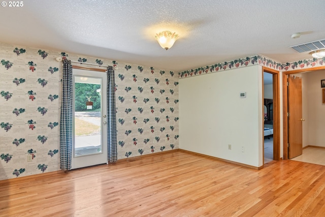 230 S Maple Hill Rd, Kelso, WA 98626 - unfurnished room with wallpapered walls, light wood-type flooring, a textured ceiling, baseboards, and a smoke detector