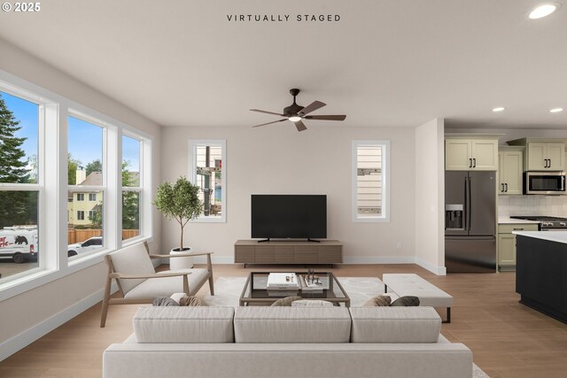 living room featuring ceiling fan and light wood-type flooring