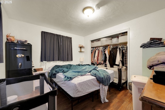 bedroom with a textured ceiling, a closet, and wood finished floors