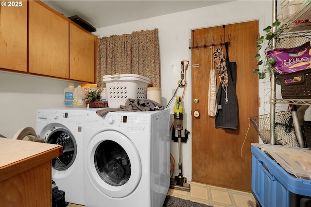 laundry area featuring separate washer and dryer and cabinet space