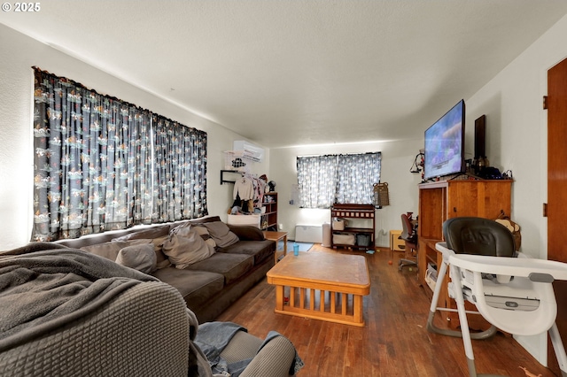 living room with a wall mounted air conditioner and wood finished floors