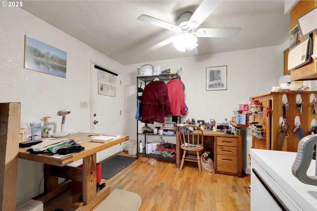 office area featuring light wood finished floors, ceiling fan, and a textured ceiling