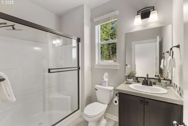 bathroom featuring an enclosed shower, vanity, and toilet