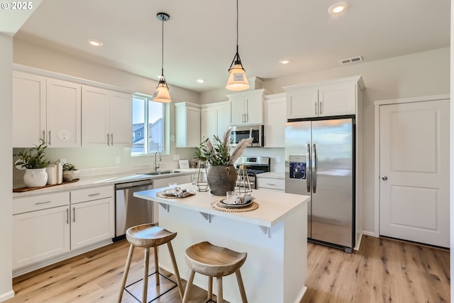 11331 NW Main St, North Plains, OR 97133 - kitchen featuring stainless steel appliances, a sink, white cabinets, light countertops, and recessed lighting