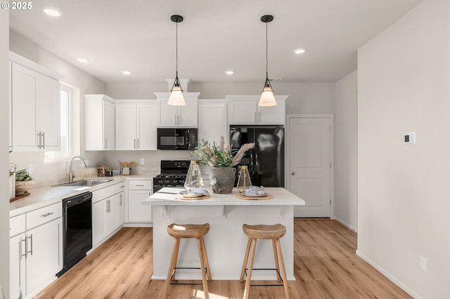 11331 NW Main St, North Plains, OR 97133 - kitchen with black appliances, a sink, a kitchen island, light wood finished floors, and recessed lighting
