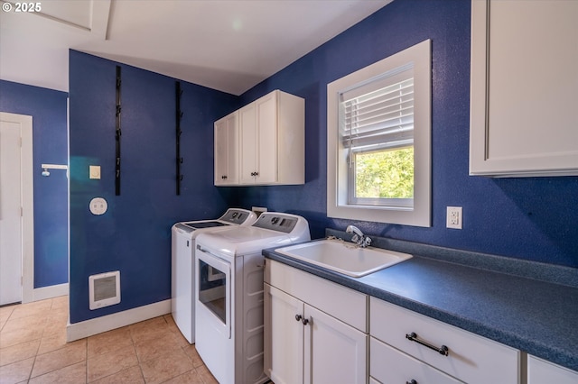 2318 Liberty St, North Bend, OR 97459 - washroom with cabinet space, washing machine and dryer, light tile patterned floors, and baseboards