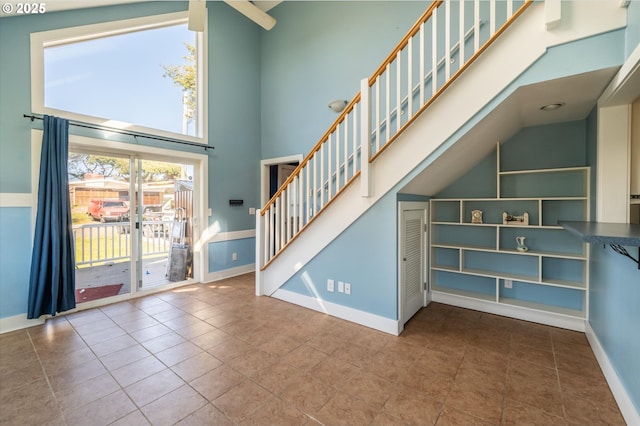 2318 Liberty St, North Bend, OR 97459 - staircase with tile patterned flooring, high vaulted ceiling, and baseboards