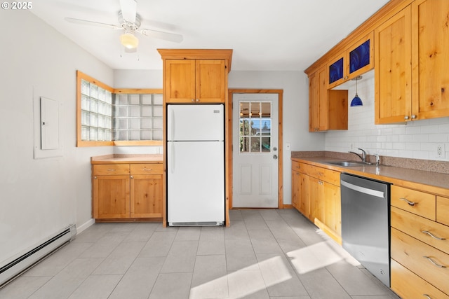 kitchen featuring dishwasher, sink, decorative backsplash, white refrigerator, and a baseboard heating unit