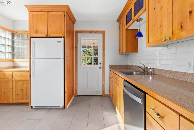 kitchen with decorative light fixtures, dishwasher, sink, decorative backsplash, and white refrigerator