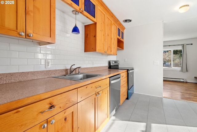 kitchen featuring pendant lighting, sink, baseboard heating, stainless steel appliances, and decorative backsplash