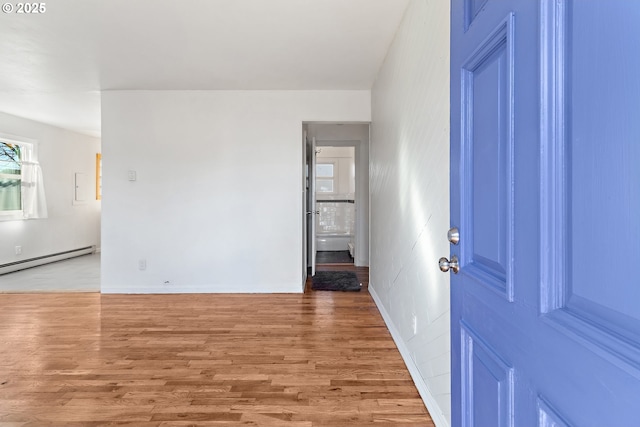 unfurnished room featuring a baseboard radiator and hardwood / wood-style floors