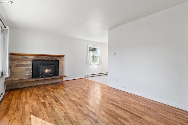 unfurnished living room featuring a baseboard heating unit and light wood-type flooring