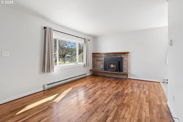 unfurnished living room with a baseboard radiator, a fireplace, and hardwood / wood-style floors