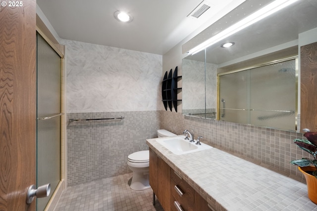 full bathroom with vanity, visible vents, tile patterned floors, toilet, and a shower with door