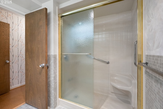 bathroom featuring a shower stall and wallpapered walls