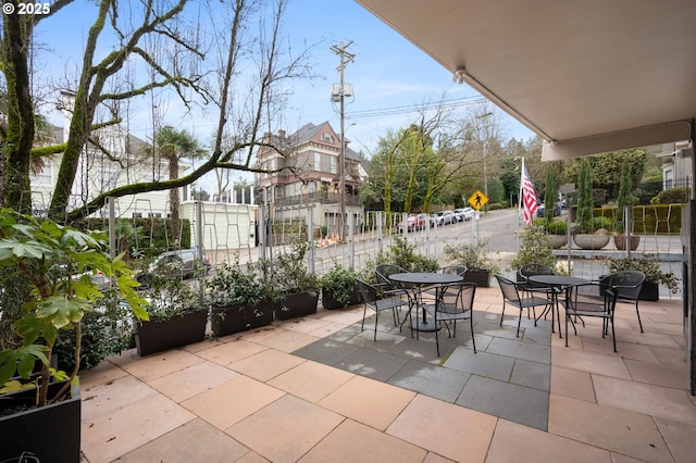 view of patio featuring outdoor dining area and fence