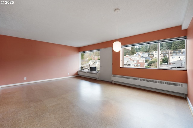 empty room with baseboards and a textured ceiling