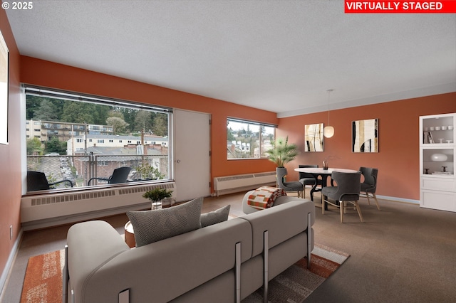 carpeted living area featuring radiator heating unit, baseboards, and a textured ceiling