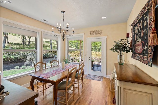 2809 Dead Indian Memorial Rd, Ashland, OR 97520 - dining area with baseboards, visible vents, light wood-style flooring, and a notable chandelier