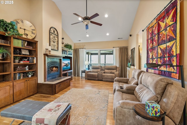 2809 Dead Indian Memorial Rd, Ashland, OR 97520 - living area with high vaulted ceiling, ceiling fan, a warm lit fireplace, and wood finished floors