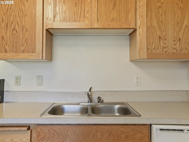 kitchen featuring dishwasher, light countertops, and a sink