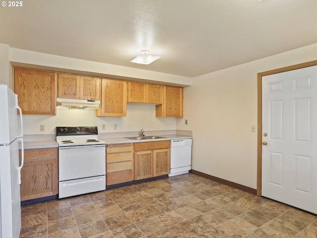 kitchen with white appliances, light countertops, under cabinet range hood, and a sink