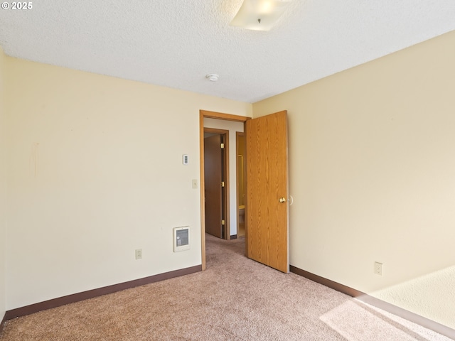 spare room with baseboards, visible vents, carpet floors, and a textured ceiling