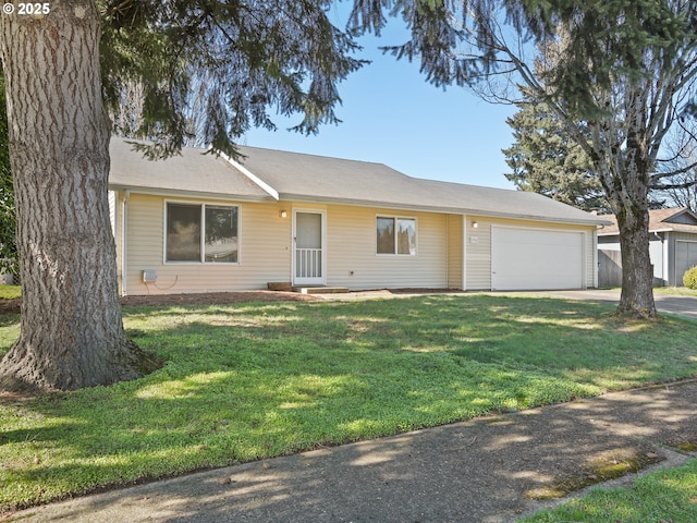 ranch-style house featuring a front yard, an attached garage, and driveway