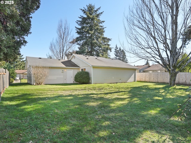 rear view of property with a lawn and fence