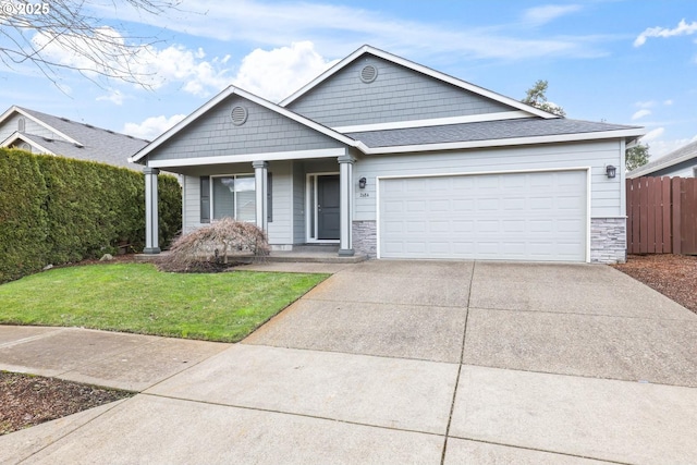 view of front of property featuring a garage, a front yard, and a porch