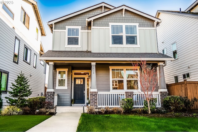 craftsman-style house featuring covered porch and a front yard