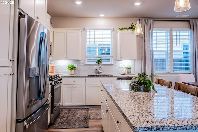 kitchen featuring pendant lighting, sink, stainless steel appliances, and a kitchen island