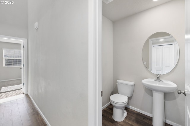 bathroom with hardwood / wood-style flooring and toilet