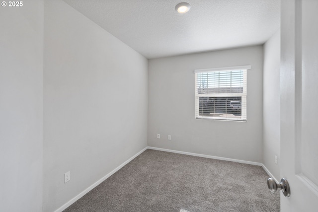 spare room with a textured ceiling and carpet