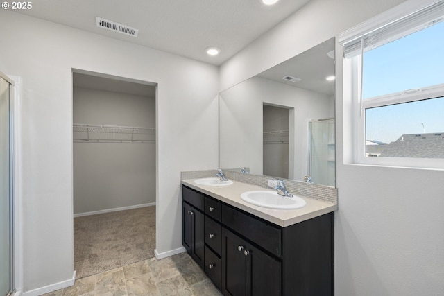 bathroom with vanity and a shower with shower door