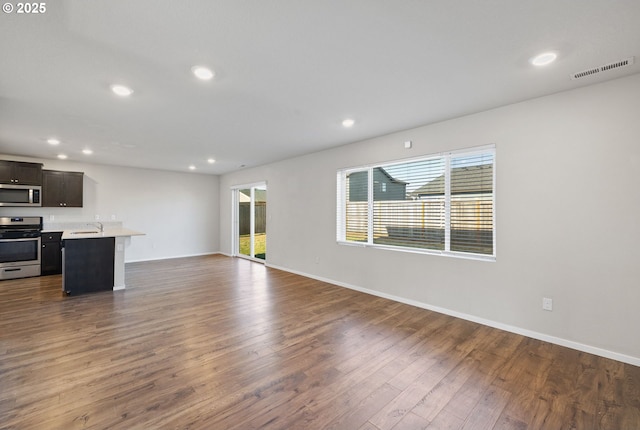 unfurnished living room with dark hardwood / wood-style floors and sink