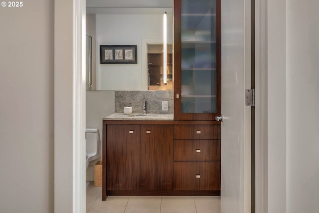 bathroom with vanity, backsplash, tile patterned floors, and toilet