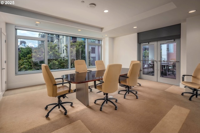 carpeted home office with a raised ceiling and french doors