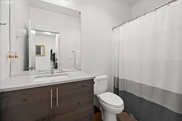 bathroom featuring toilet, vanity, wood finished floors, and curtained shower