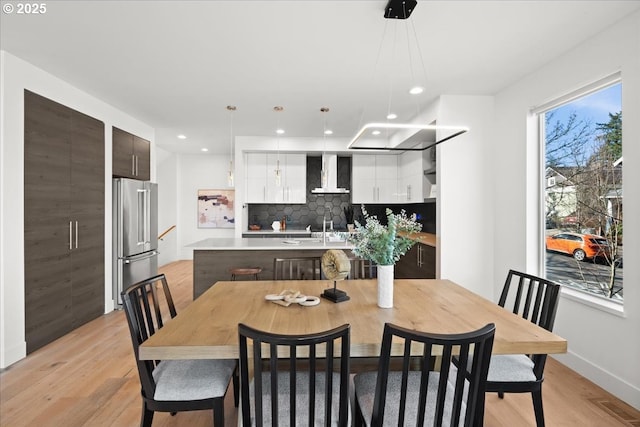 dining area with light wood finished floors, recessed lighting, and baseboards