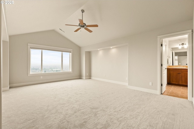 interior space featuring ceiling fan, light carpet, sink, and lofted ceiling