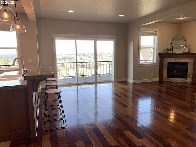 unfurnished living room featuring dark hardwood / wood-style flooring, a tiled fireplace, and sink