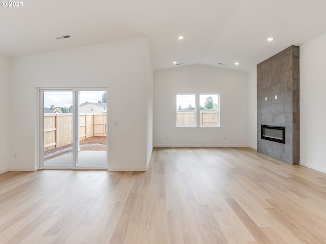 356 NW 29th Way, Battle Ground, WA 98604 - unfurnished living room featuring a tile fireplace, light wood-style flooring, lofted ceiling, recessed lighting, and baseboards