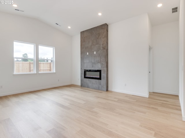 356 NW 29th Way, Battle Ground, WA 98604 - unfurnished living room featuring lofted ceiling, light wood-style floors, a tile fireplace, recessed lighting, and baseboards