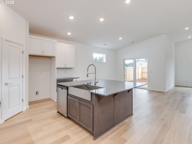 356 NW 29th Way, Battle Ground, WA 98604 - kitchen with stainless steel dishwasher, a sink, white cabinets, light wood-type flooring, and a kitchen island with sink