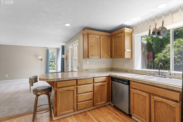 20198 SW Tillamook Ct, Tualatin, OR 97062 - kitchen with stainless steel dishwasher, a peninsula, light countertops, a textured ceiling, and recessed lighting