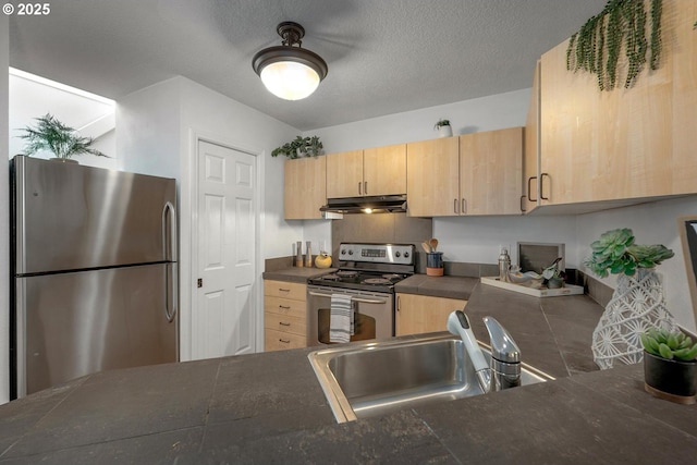 1535 SW Clay St Unit 238, Portland, OR 97201 - kitchen with appliances with stainless steel finishes, dark countertops, light brown cabinets, under cabinet range hood, and a sink