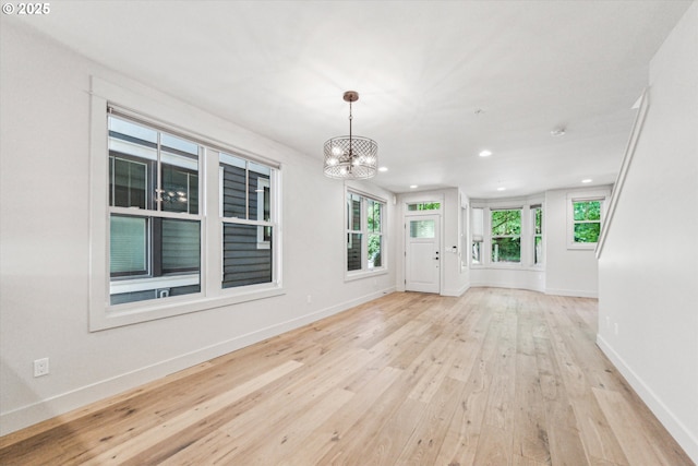 unfurnished dining area featuring light wood-style floors, recessed lighting, a chandelier, and baseboards